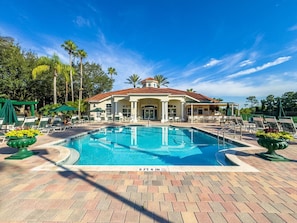 A pool area with a building in the background, surrounded by palm trees and lounge chairs. - Last Minute Disney Getaway! Townhouse with Private Pool. Book Now! #107649 (Orlando)