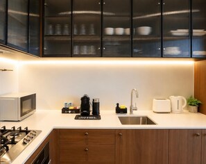 A modern kitchen with a gas stove, microwave, coffee maker, toaster, and a sink. - Sea & Skyline Views | Pool, Gym & Sauna (Southbank)