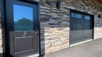 A building with a stone facade and two garage doors.