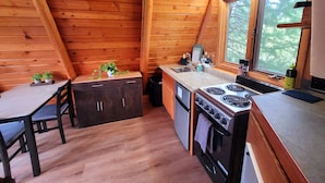 Une cuisine de taille réduite avec des murs en bois, une table à manger et une fenêtre.