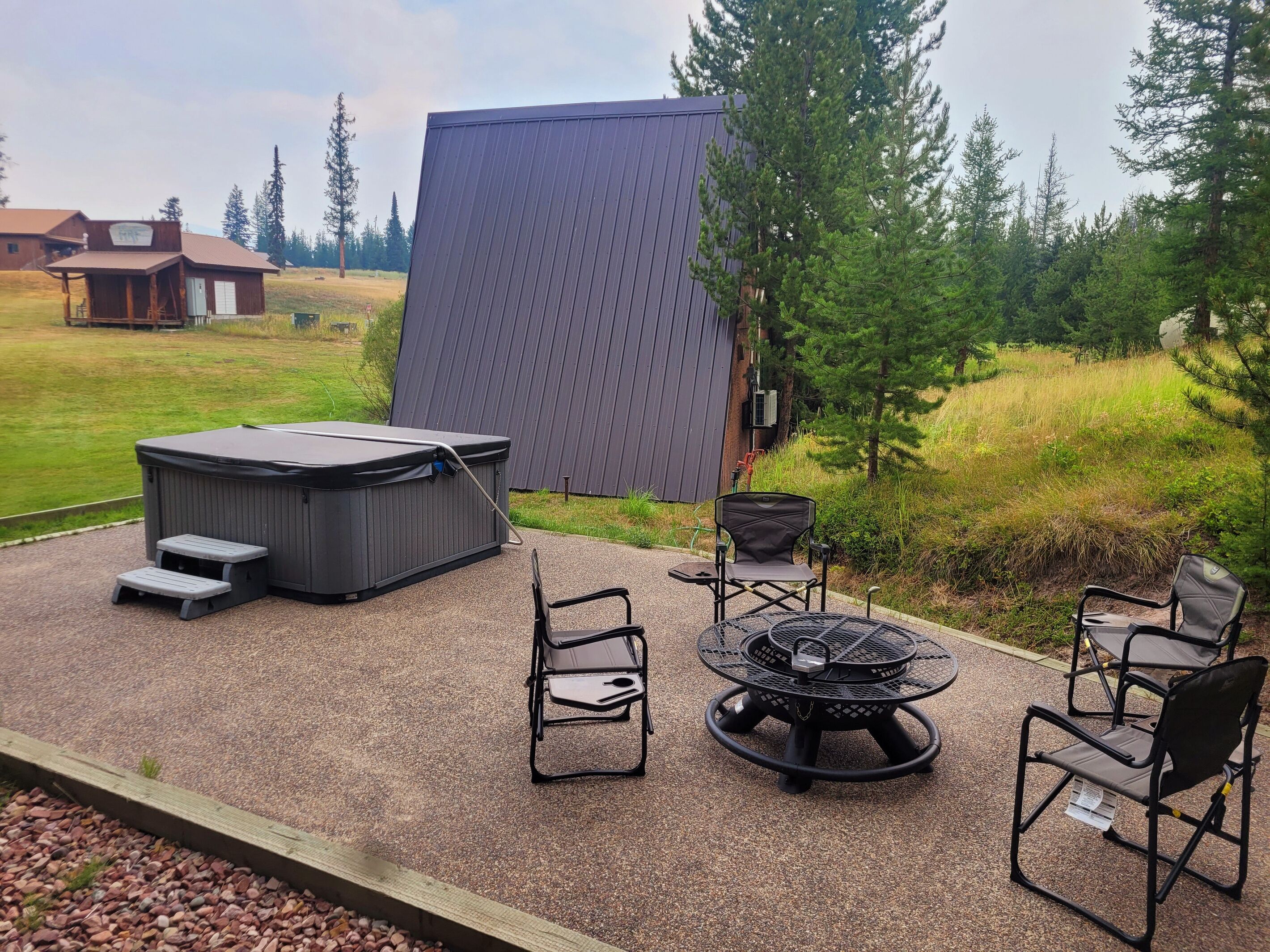 Un jacuzzi con escalones, un brasero y mobiliario exterior.