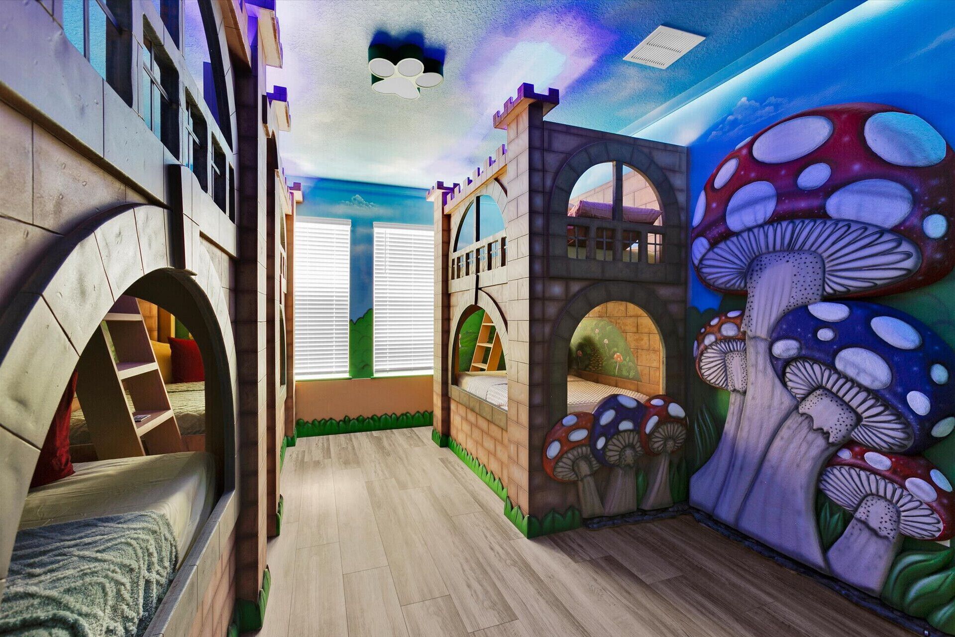 Une salle de jeux pour enfants avec un toboggan, des sièges en forme d’arche et une fresque murale représentant des champignons.