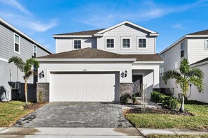 A two-story residential house with a garage, a stone foundation, and a brick driveway. - Last Minute Disney Getaway! Luxury Villa with Private Pool. Book Now! #112733 (Orlando)