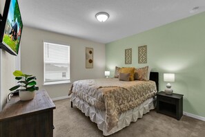 A bedroom with a bed, bedside tables, a TV, and a window with blinds. - Last Minute Disney Getaway! Luxury Villa with Private Pool. Book Now! #112733 (Orlando)