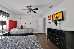 A bedroom with a bed, a dresser, a ceiling fan, and a wall with heart-shaped decorations. - Last Minute Disney! Private Pool, Hot Tub, Game Room & Themed Bedrooms. Book Now! #113415 (Orlando)