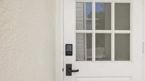 Una puerta blanca con teclado electrónico y timbre.