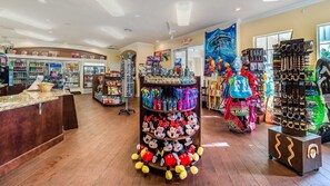Una tienda con estantes llenos de peluches, una exhibición de figuras de Mickey Mouse y varios recuerdos.