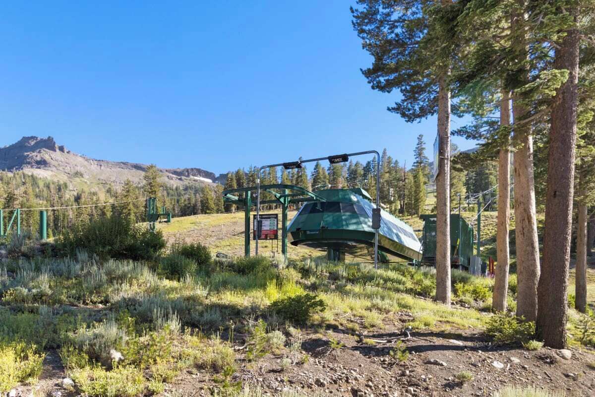 A ski lift in a mountainous area with a clear sky.