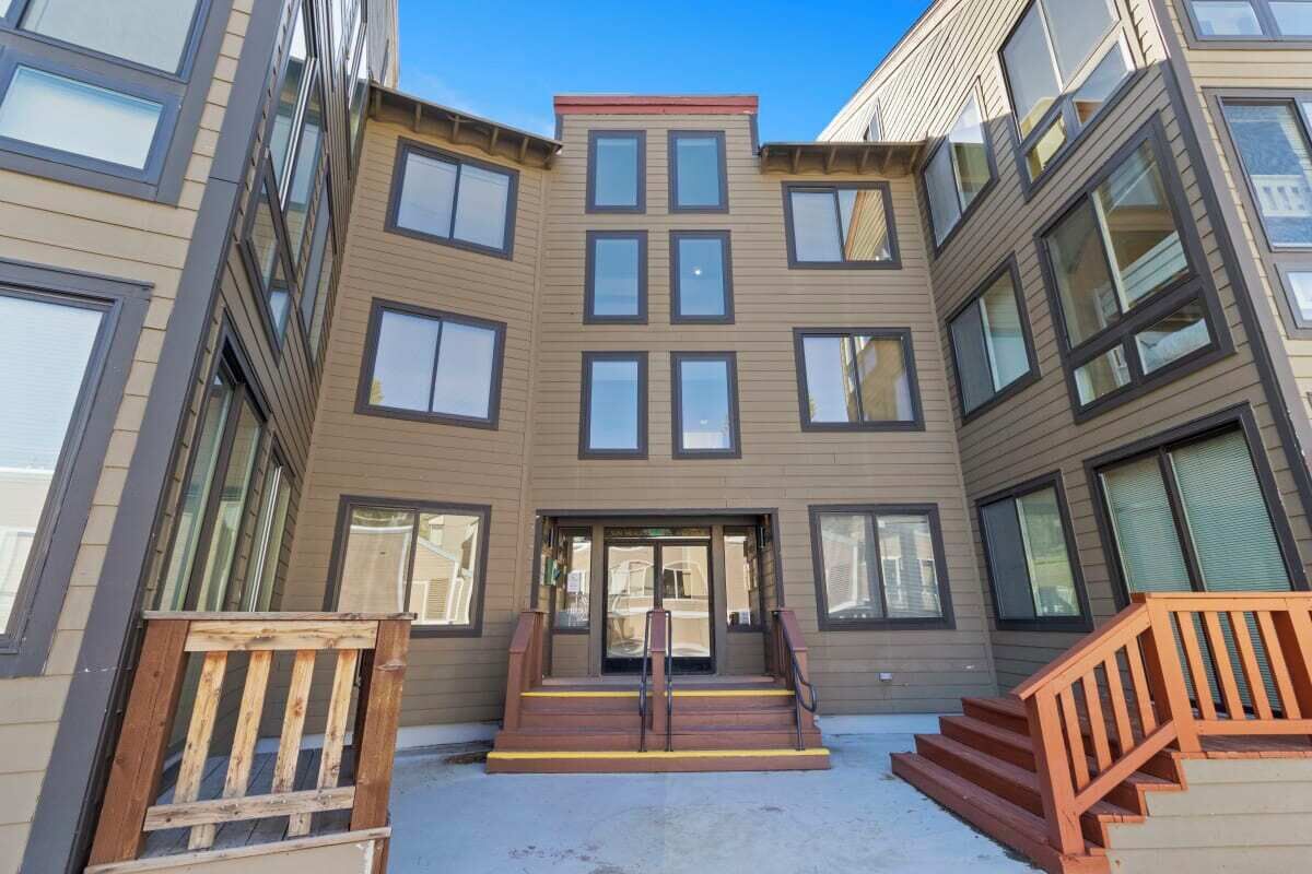 A multi-story building with a central entrance, a staircase, and a ramp.