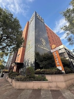 Un hotel con un letrero llamativo, una fachada moderna y un cielo despejado.