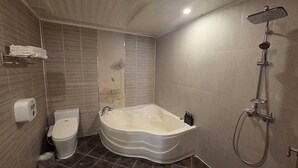 Ein Badezimmer mit einer freistehenden Badewanne, einer Toilette und einer Duschkabine.