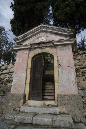 A stone structure with a wooden door and steps leading up to it.