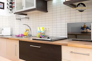 Una cocina moderna con salpicadero de azulejos blancos, electrodomésticos de acero inoxidable y encimera de madera.