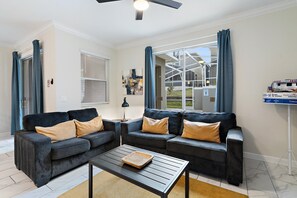 Un salon moderne avec deux canapés, une table basse et un ventilateur de plafond.
