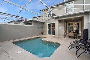 Una piscina interna con tetto in vetro, una zona relax con sedute e vista sul cielo.