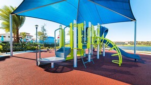 A playground with a slide, climbing structures, and a covered seating area. - Last Minute Disney! Private Pool, Hot Tub & Themed Bedrooms. Book Now! #107657 (Orlando)