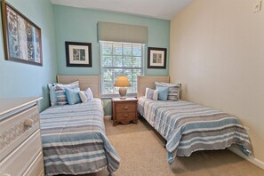 A bedroom with two beds, a nightstand, a lamp, and framed pictures on the walls. - Windsor Palms 83 - Three Bedroom Apartment, Sleeps 6 (Orlando)