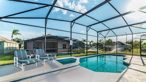 A pool area with a clear view of the surrounding neighborhood, including houses and a covered seating area with chairs. - Windsor Palms 82 - Four Bedroom Villa, Sleeps 8 (Orlando)