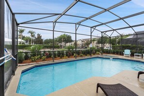 A pool area with a covered structure, clear sky, and surrounding greenery. - Windsor Palms 75 - Four Bedroom Villa, Sleeps 10 (Orlando)