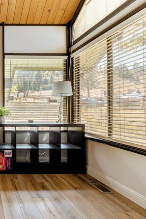A room with a large window, a lamp, and a bench with storage boxes. - Premier Townhouse, Closest to the Slopes (Big Bear Lake)