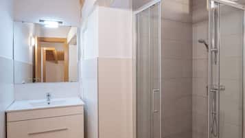 Apartamento (2 habitaciones) | Baño | Ducha, artículos de higiene personal gratuitos y secador de pelo