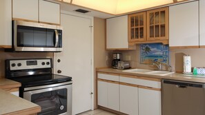 A compact kitchen with a microwave, stove, coffee maker, and a sink. - Siesta Key 231 - Three Bedroom Apartment, Sleeps 8 (Siesta Key)
