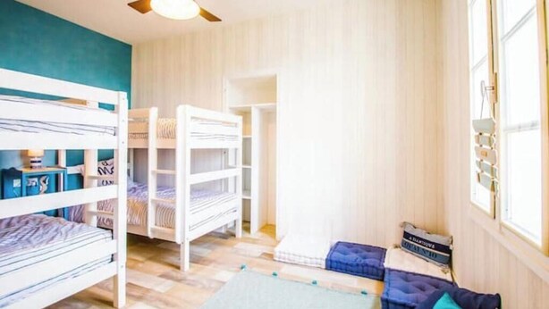 A room with bunk beds, a ceiling fan, and a window with curtains. - "Côté sauvage" 4-star vacation rental for 16 people (La Tremblade)
