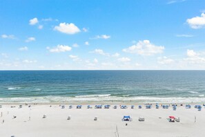 A beach with white sand, a clear blue sky, and the ocean. - Phoenix 5 910 (Orange Beach)