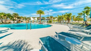 A pool area with lounge chairs and palm trees. - Solara Resort 330 - Nine Bedroom Villa, Sleeps 22 (Orlando)