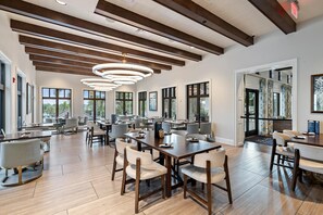 A spacious dining area with multiple tables and chairs, large windows, and a modern ceiling design. - Solara Resort 330 - Nine Bedroom Villa, Sleeps 22 (Orlando)