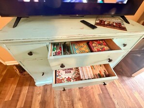A light blue wooden cabinet with multiple drawers, each containing various items such as pens, markers, and a coloring book.