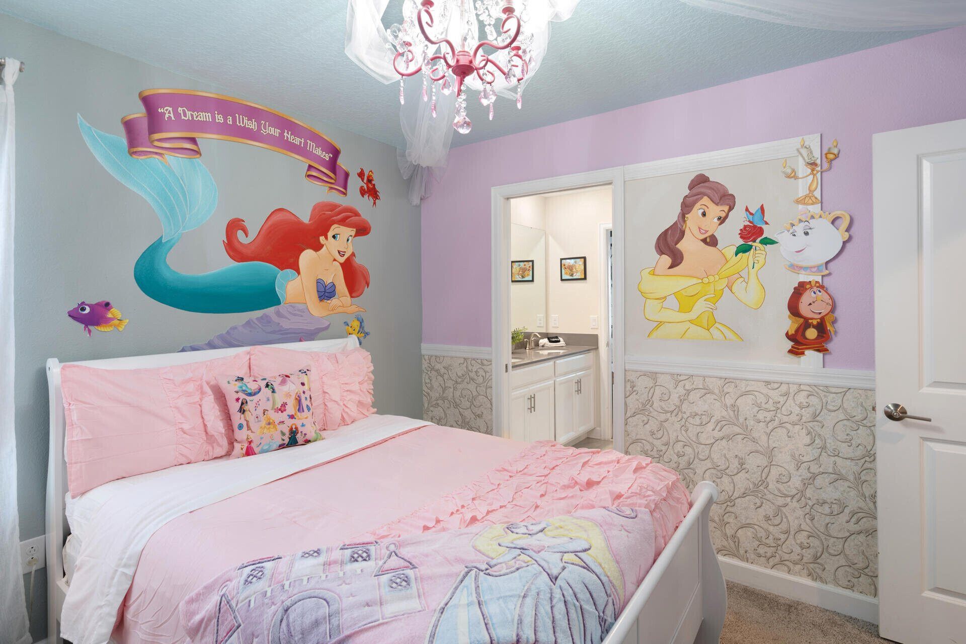 A bedroom with a bed, a dresser, a mirror, and wall decorations including a mermaid and a princess.