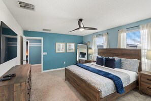 A bedroom with a bed, bedside tables, a dresser, a ceiling fan, and a window with curtains. - Championsgate 923 - Eight Bedroom Villa, Sleeps 20 (Orlando)