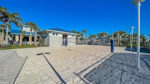 A beachside hotel with a pool area, palm trees, and a clear blue sky. - Windsor Island Resort 463 (Orlando)