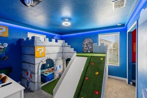 A playroom with a slide, castle play structure, and a character mural. - Championsgate 931 - Eight Bedroom Villa, Sleeps 20 (Orlando)