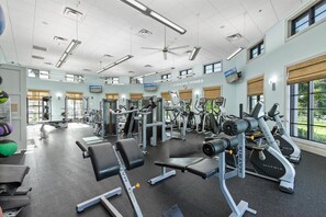A gym with various exercise equipment, large windows, and a ceiling fan. - Championsgate 931 - Eight Bedroom Villa, Sleeps 20 (Orlando)