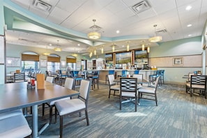 A restaurant with a bar area, multiple seating options, and a view of the outdoors.