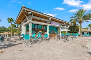 Un bar frente a la playa con terraza y patio de baldosas.