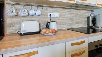 Cafetera o tetera, microondas, horno y placa de cocina