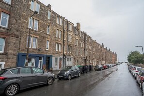 Uma fileira de casas geminadas com carros estacionados na rua.