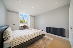 A bedroom with a bed, a radiator, and a window. - Cosy and Stylish Flat in Notting Hill - Pass the Keys (London)