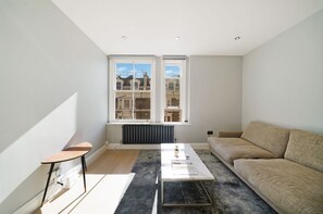 Een moderne woonkamer met een bank, een salontafel en een radiator.