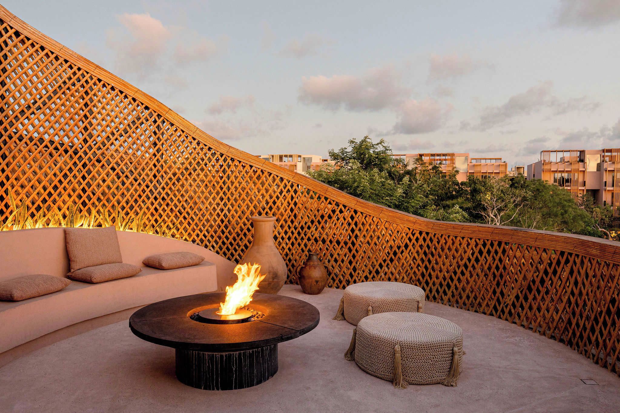 Una terrazza sul tetto con un braciere, un'area salotto e un recinto decorativo.
