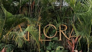 A lush indoor garden with a wooden sign spelling 'ATLAS.' - Aflora Moon 3 bd First FloorBeach Club + Breakfast (Tulum)