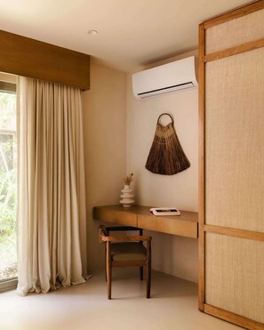Ein Zimmer mit Schreibtisch, Stuhl und Klimaanlage.