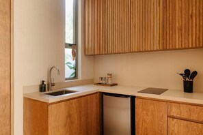 Une cuisine moderne avec des meubles en bois, un évier en acier inoxydable et une machine à café.
