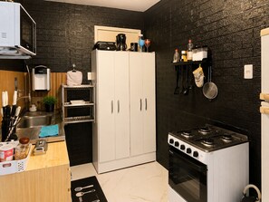 A compact kitchen with a microwave, stove, and cabinets.