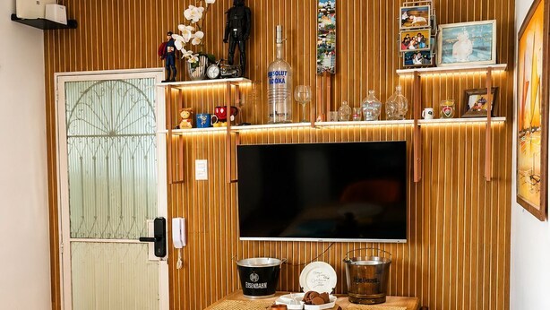 Ein Essbereich mit einem Holztisch, Stühlen und einem an der Wand befestigten Fernseher.