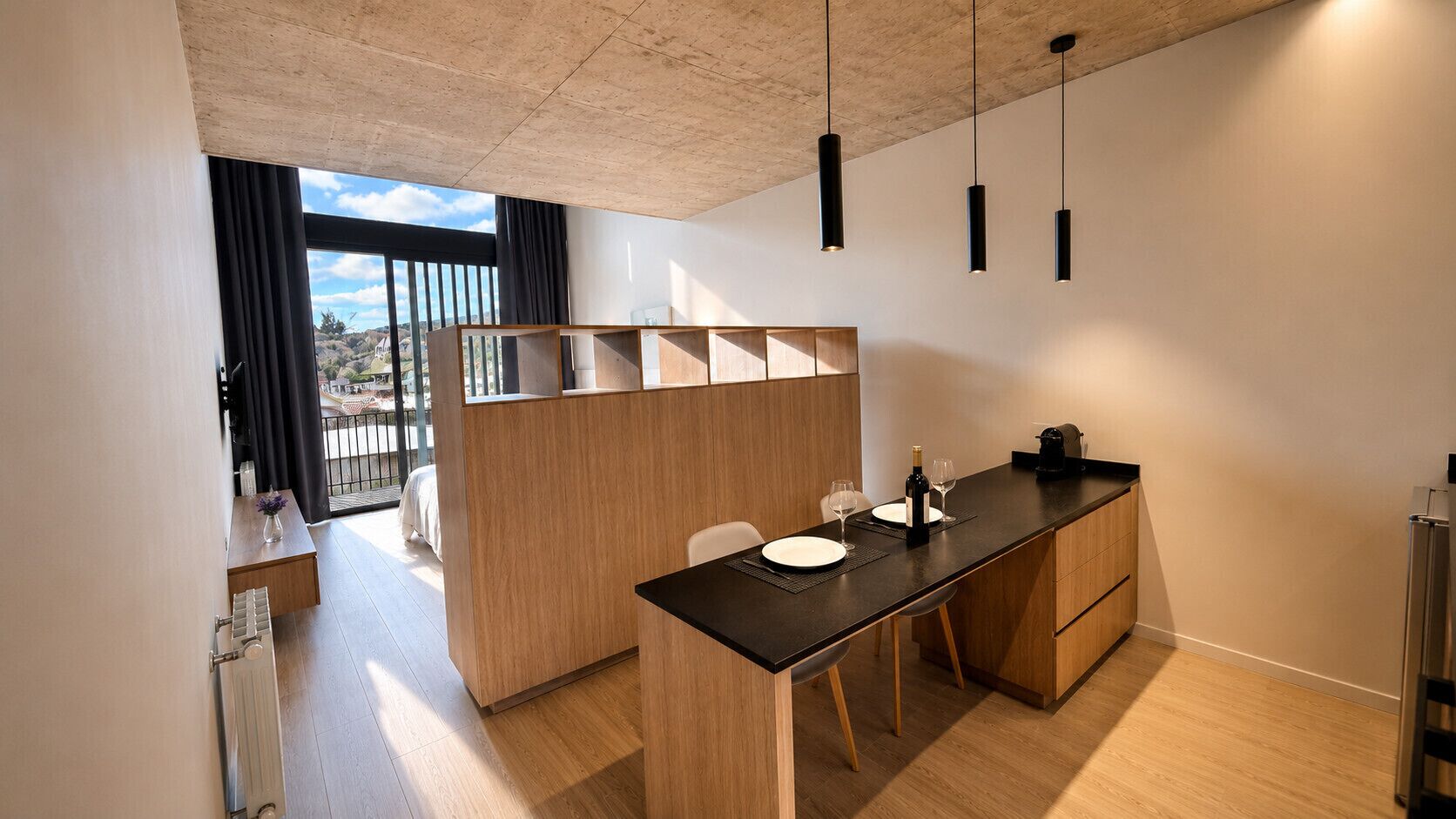 Uma cozinha moderna com uma ilha central, armários de madeira e iluminação pendente.