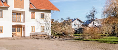 Ein großes, weißes Gebäude mit rotem Ziegeldach, zahlreichen Fenstern und einem gepflasterten Innenhof.